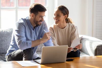 Couple sitting in front of computer calculates their mortgage payments and creates an amortization schedule.