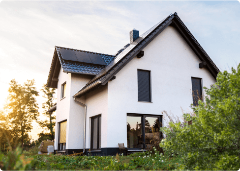 The outside view of a white energy-efficient home with solar panels on the roof